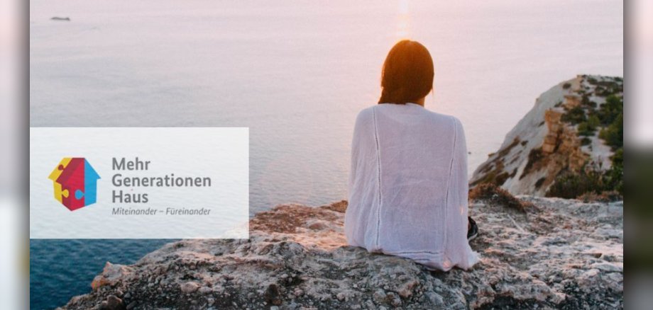 Symbolbild: Frau von Hinten, die auf einem Felsen Richtung Meer blickt