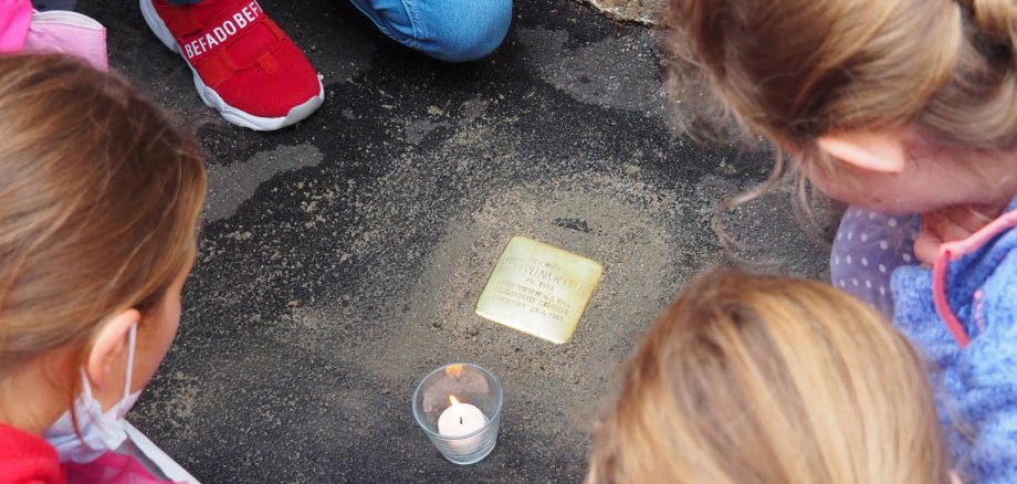 Kinder betrachten den Stolperstein für Magdalena Köhler.