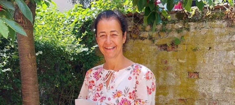 Die Eltviller wellcome-Koordinatorin Nicole Hoffmann steht im Garten mit ihrer Urkunde in der Hand.