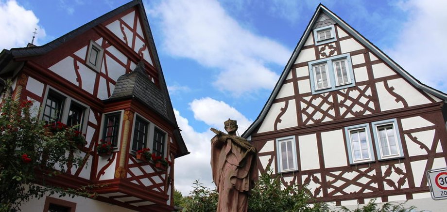 Fachwerk in Erbach Zwei Fachwerkhäuser, mittig steht eine Statue.