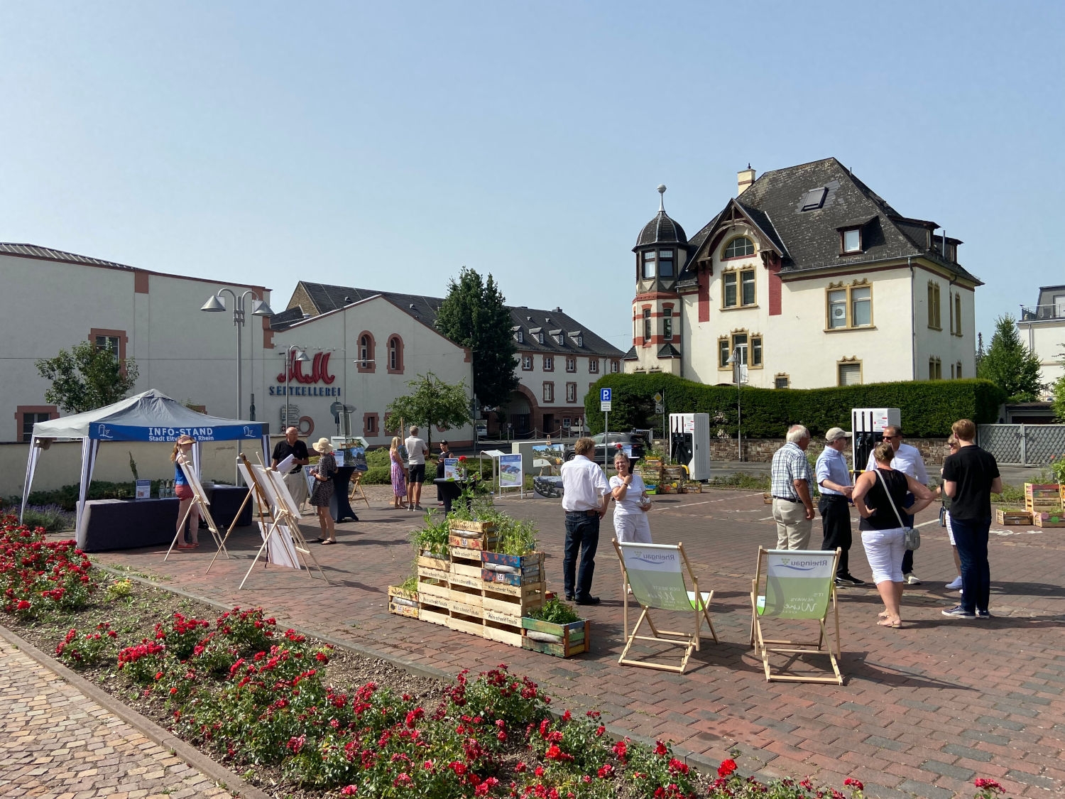 Bei den Aktionstagen konnten sich die Besucher am Infostand der Stadt informieren. Mehrere Besucher stehen in Gruppen auf dem Parkplatz am Kiliansring, der mit einem Infostand der Stadt, Pflanzkisten und den Animationen zur Neugestaltung geschmückt ist.