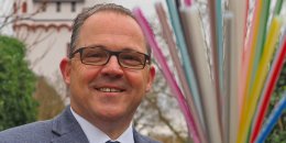 Bürgermeister Patrick Kunkel steht vor der Kurfürstlichen Burg und hält einen Straß Glasfaserkabel in den Händen.