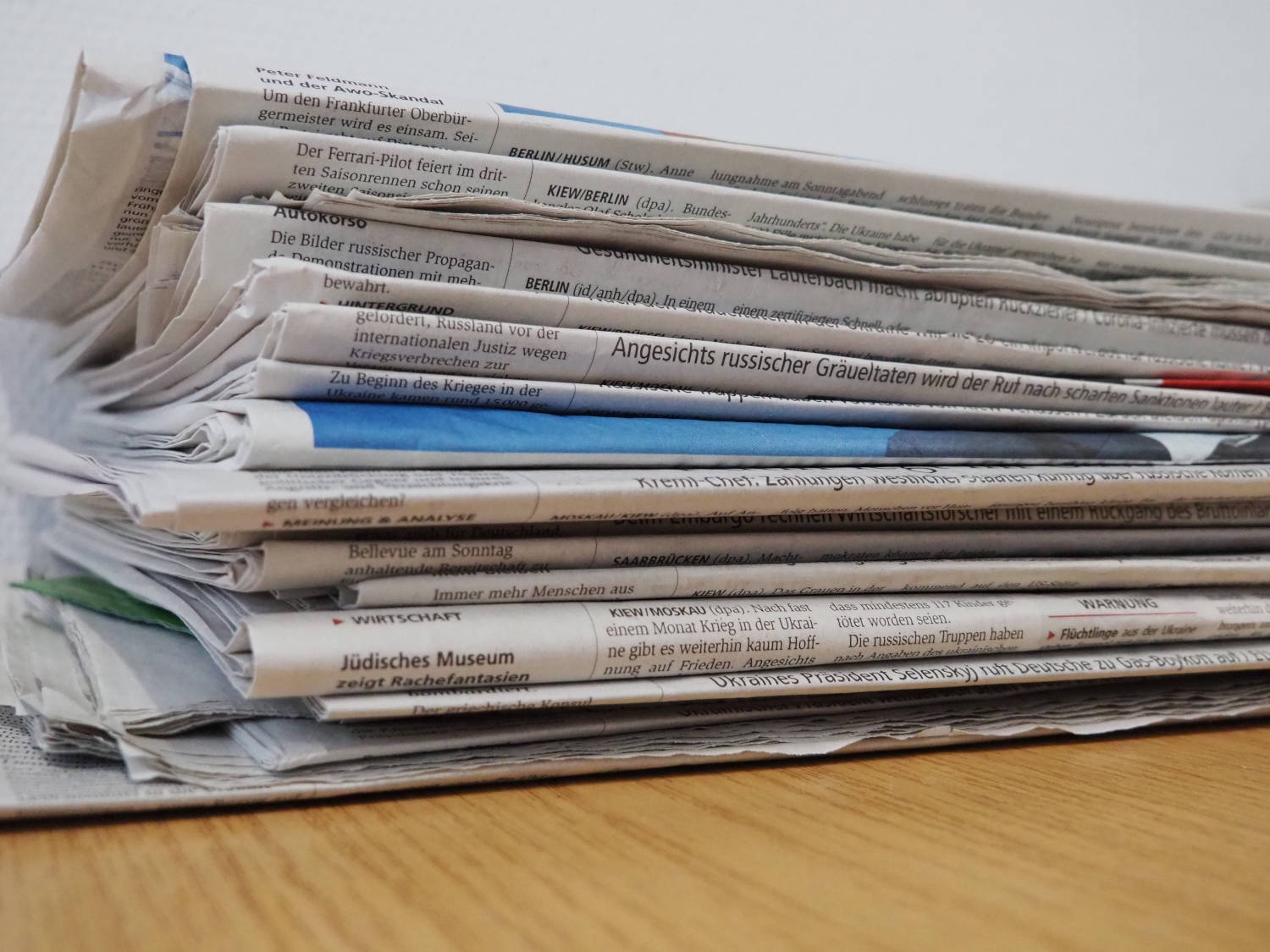 Symbolbild Presse / News Ein Stapel Zeitungen liegt auf einem Tisch.