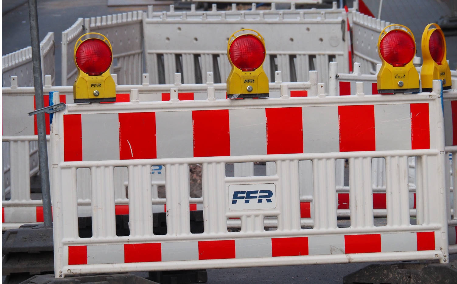 Symbolbild Straßensperrung Rot-weißes Absperrgitter auf einer Straße.