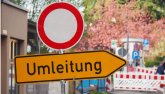 Symbolbild Straßensperrung Ein Straßensperrschild und ein Schild mit der Aufschrift "Umleitung" im Hintergrund sieht man, dass die Straße abgesperrt ist.