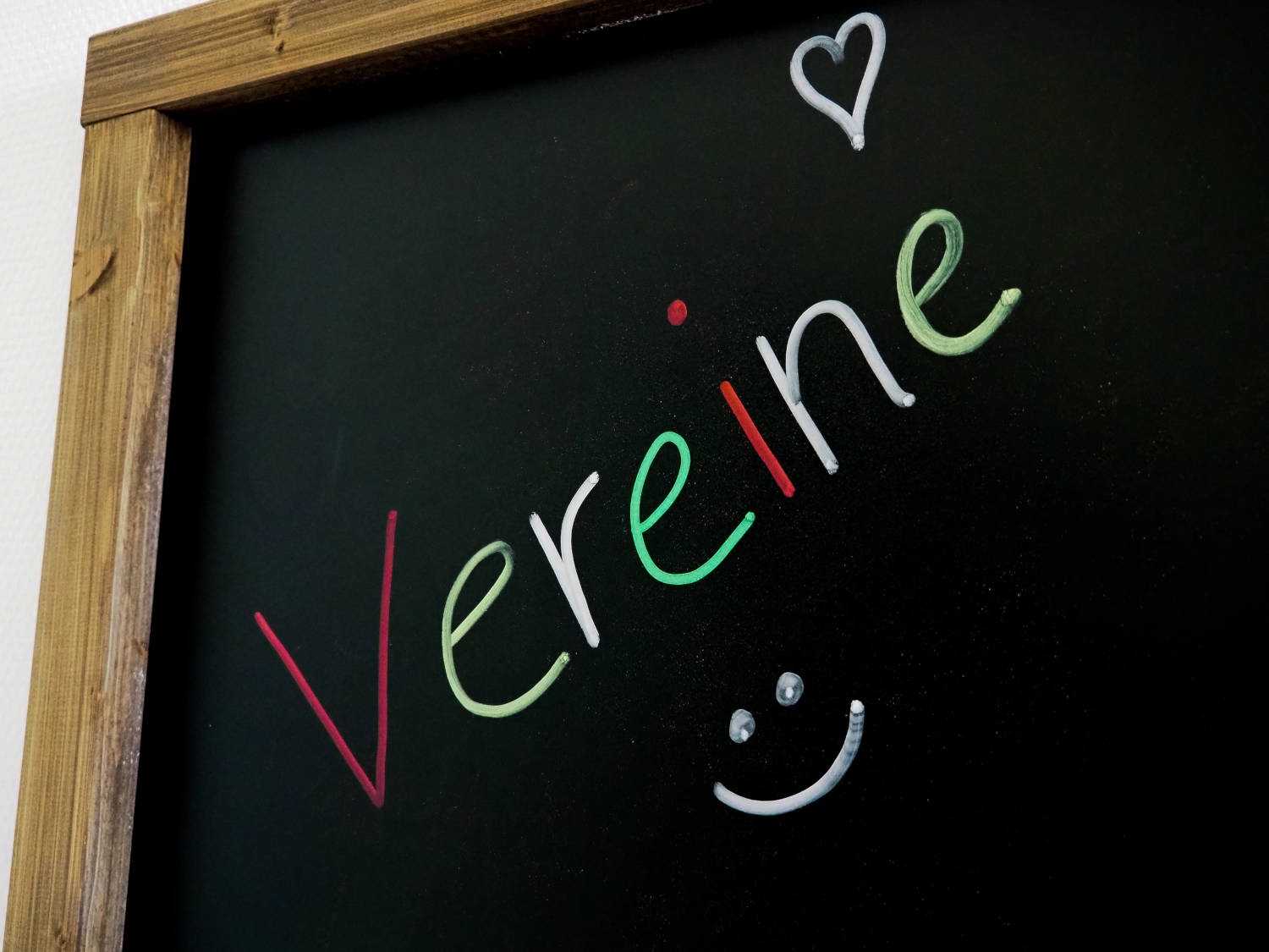 Auf einer schwarzen Tafel steht mit bunter Kreide "Vereine" geschrieben.