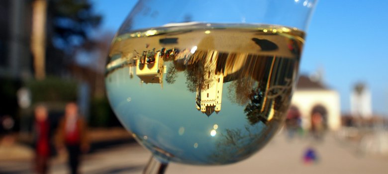 Die Kurfürstliche Burg spiegelt sich in einem Weinglas.