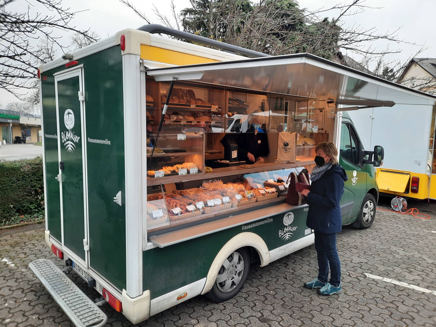 Eine Dame kauft etwas an dem Auto des Bio-Bäckers in Eltville.