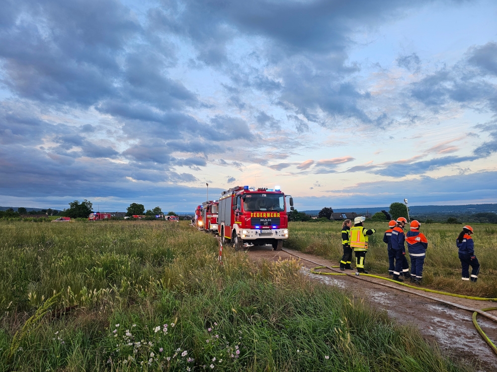 Feuerwehrauto und Jugendfeuerwehrgruppe auf einem Feldweg