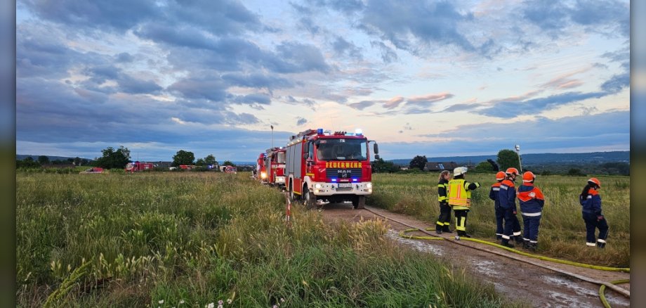Feuerwehrauto und Jugendfeuerwehrgruppe auf einem Feldweg