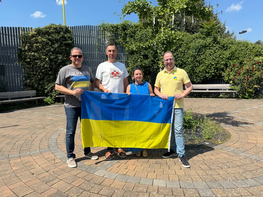 Foto der vier Akteure mit Ukraine-Flagge