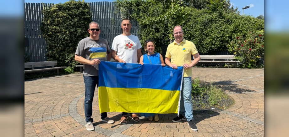 Foto der vier Akteure mit Ukraine-Flagge