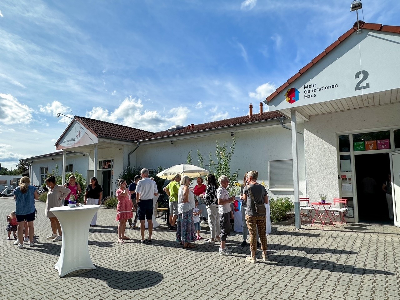 Impression vom Sommerfest, Festbesucher stehen vor dem MGH 2