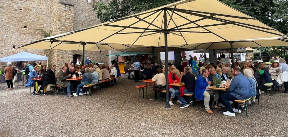 Ehrenamtsgäste sitzen auf Bänken im Burgzwinger