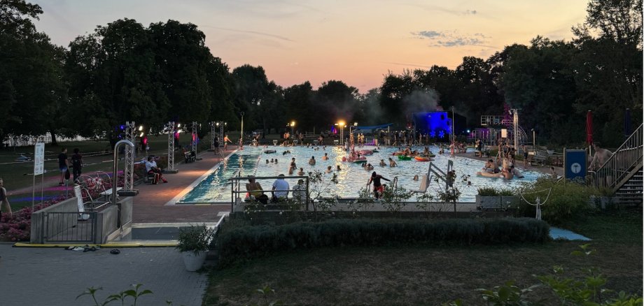 Jugendliche im Schimmbecken in der Abenddämmerung