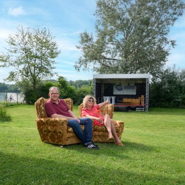 Bürgermeister und Sigrun Breithaupt sitzen auf zwei Sesseln auf der Wiese im Rosenbad, im Hintergrund sieht man die Veranstaltungsbühne