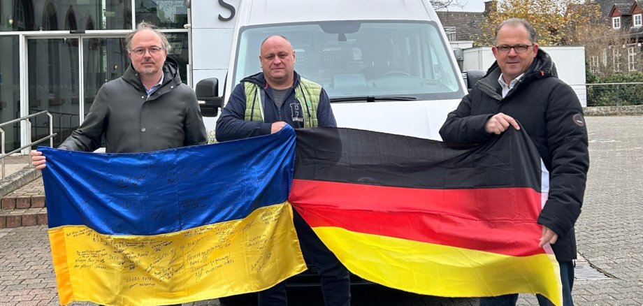 Gruppenfoto vor dem Rathaus mit ukrainischer Flagge und deutscher Flagge