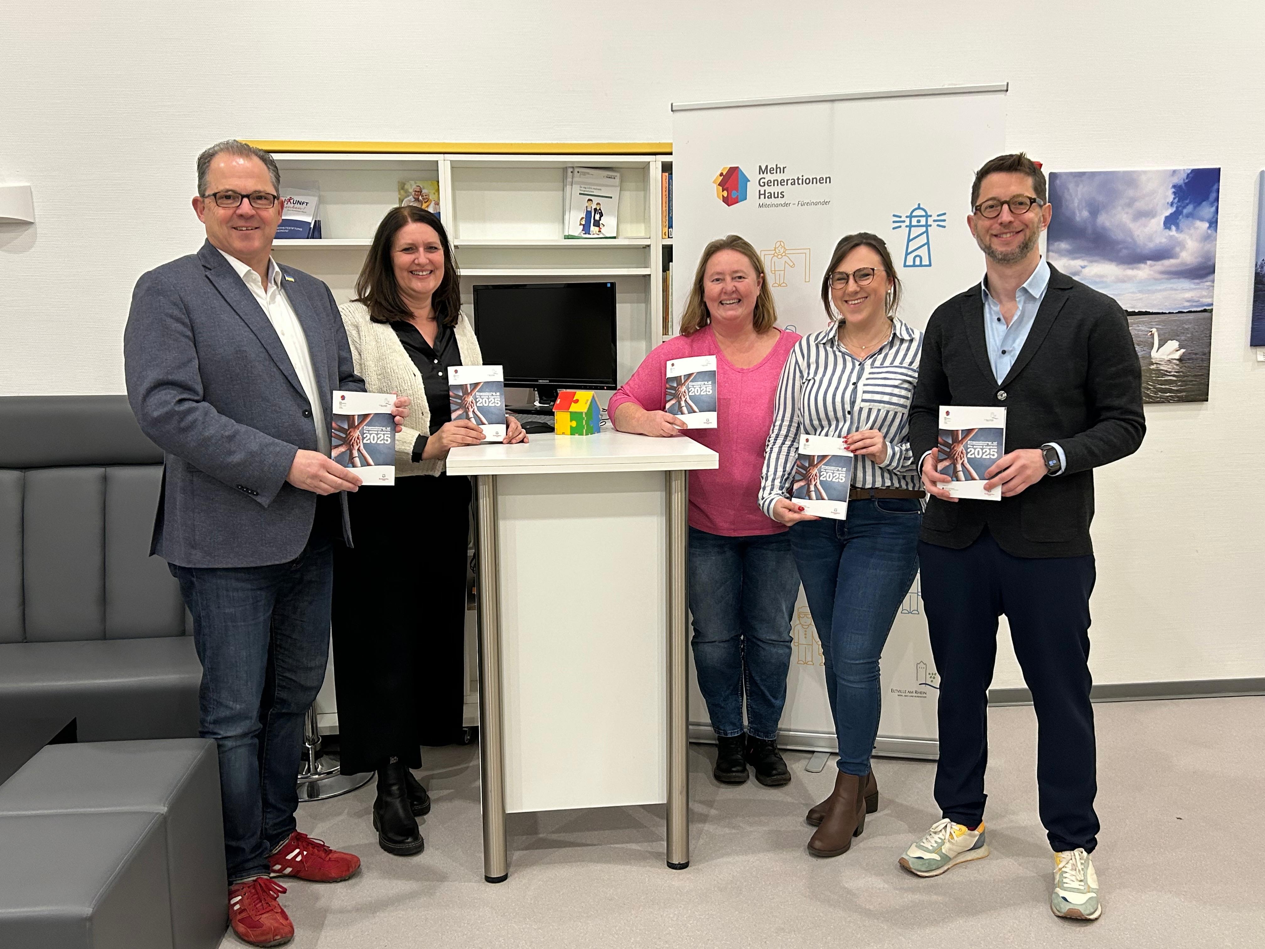 Gruppenfoto MGH-Team und Bürgermeister mit Programmheft in den Händen