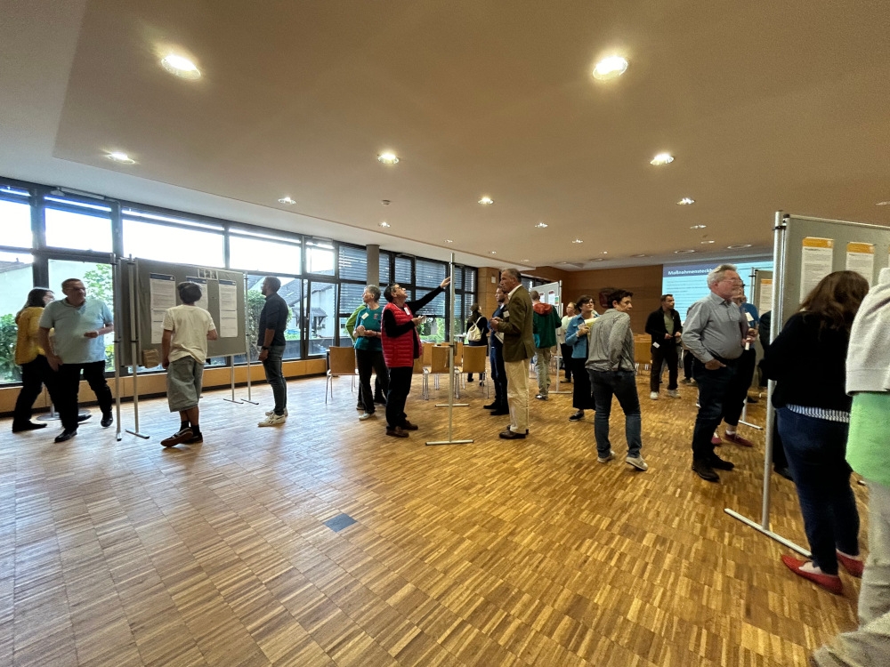 Besucher laufen durch die Galerie und informieren sich an Infotafeln