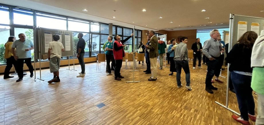 Besucher laufen durch die Galerie und informieren sich an Infotafeln