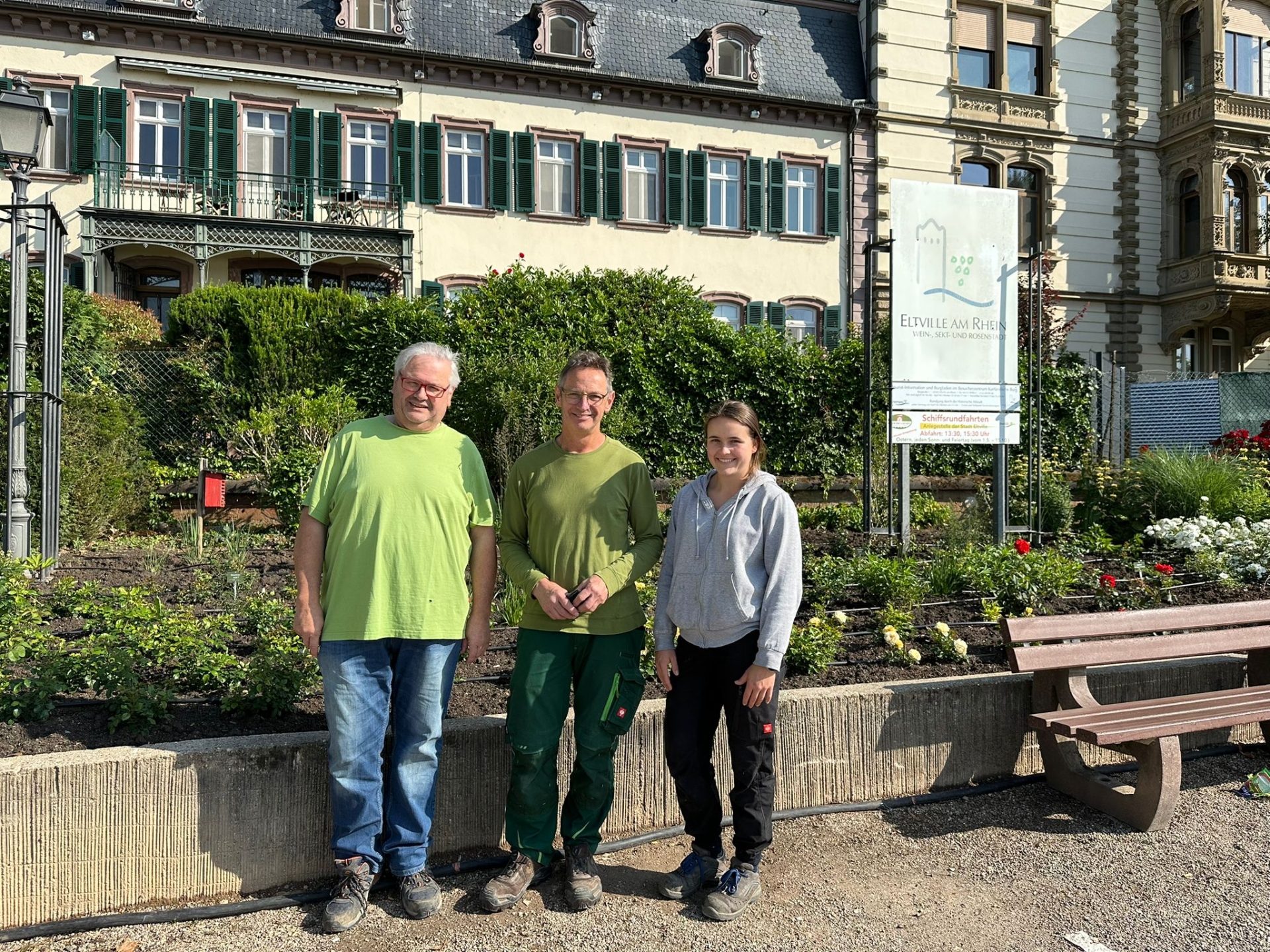 Die drei Gärtner stehen vor dem neu angelegten Beet mit neu gepflanzten Rosen