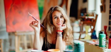 Portrait Marion Haas in ihrem Atelier mit Pinsel in der Hand