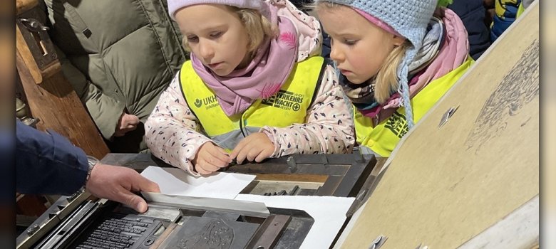 Vorschulkinder stehen um die Gutenbergpresse