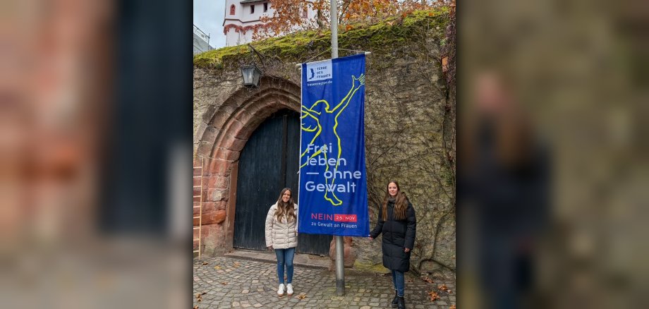 Die beiden Frauenbeauftragten vor der Burg mit gehisster Flagge "Nein gegen Gewalt an Frauen"