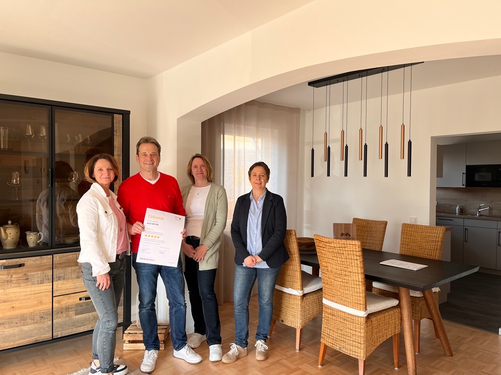 Gruppenfoto in der Ferienunterkunft mit Urkunde