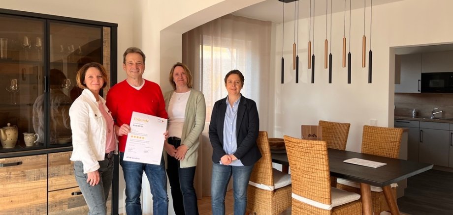 Gruppenfoto in der Ferienunterkunft mit Urkunde