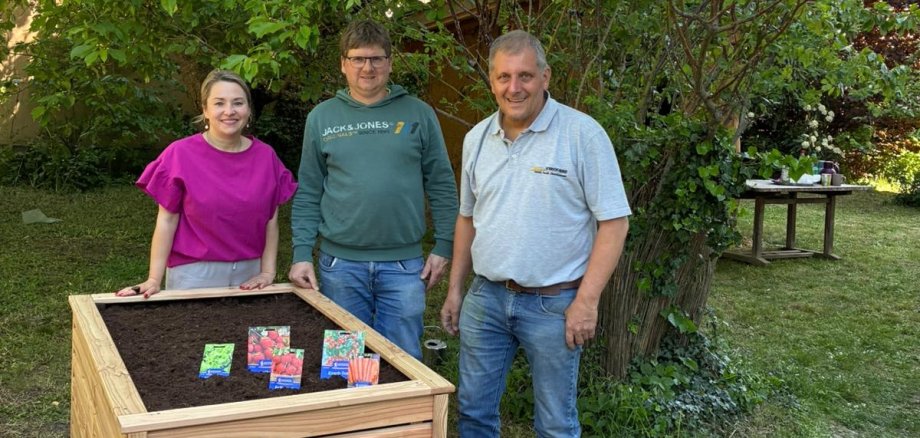 JUZ-Mitarbeiterin und zwei Herren der Firma Heinrichs Agrar stehen hinter dem neuen Hochbeet