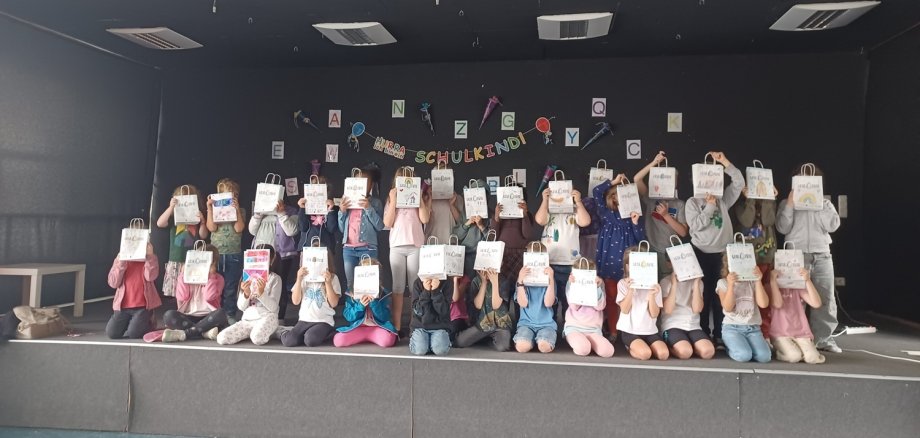 Schulkinder mit den bunten Tüten vor den Gesichtern auf einem Gruppenfoto
