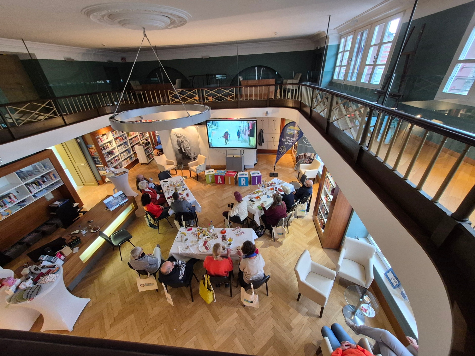 Blick von der Galerie in den Lesesaal mit Teilnehmern des Frühstücks, die dort sitzen