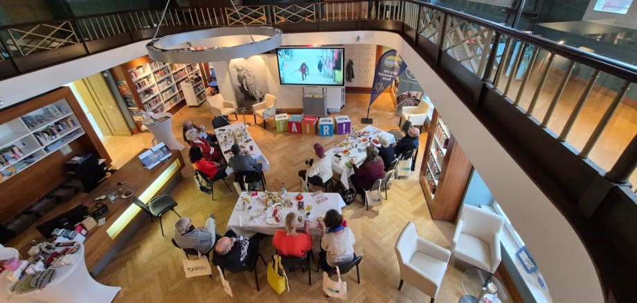Blick von der Galerie in den Lesesaal mit Teilnehmern des Frühstücks, die dort sitzen
