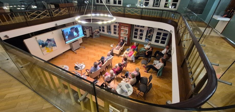 Blick von der Galerie auf die Zuschauenden im Lesesaal
