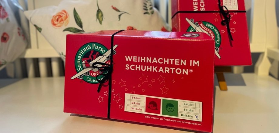 Zwei rote Pakete stehen auf einer weißen Bank