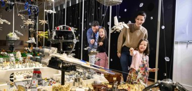 LEGO Sonderausstellung Kloster Eberbach Eine Familie, Eltern und zwei Kinder, schauen sich eine Lego Ausstellung an.